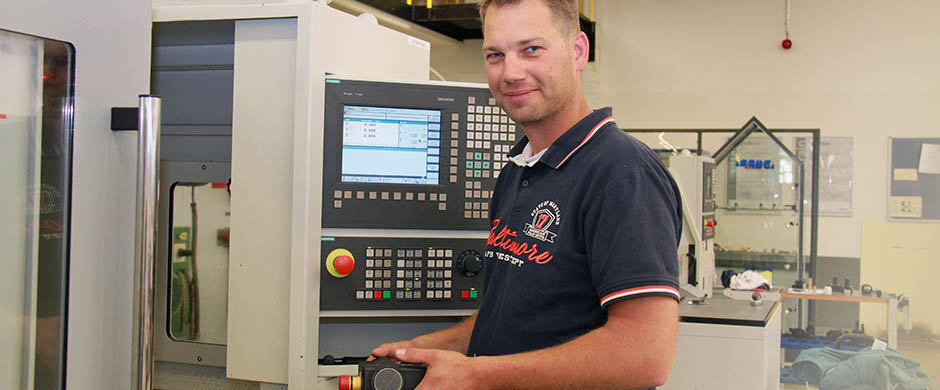 Ein Mitarbeiter bedient eine CNC-Fräsmaschine