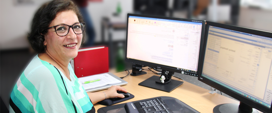 Eine Kauffrau zeigt ihrem Kollegen etwas am Bildschirm seines Computers
