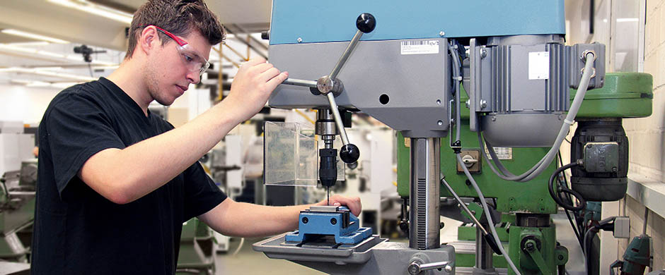 Ein junger Mann arbeitet im Rahmen der berufspraktischen Erprobung an einer Bohrmaschine