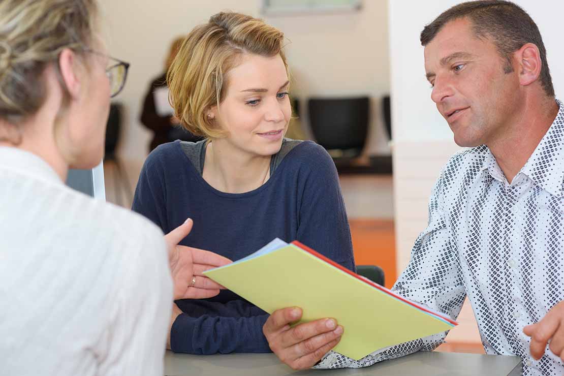 Drei Personen bei der Vorstellung eines Trainingsplanes